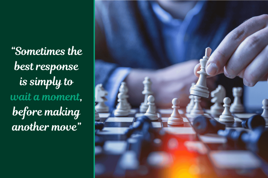 Embrace Strategic Patience to Reduce Tech Stress Close-up view of a person's hands carefully moving a chess piece on a chessboard, with the quote "Sometimes the best response is simply to wait a moment, before making another move" overlaid, conveying the idea of embracing strategic patience when interacting with technology.